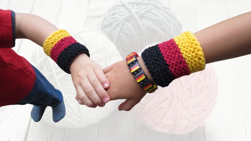 Schwarz Rot Gold Armband aus Wollresten stricken Schwarz Rot Gold Armband aus Wollresten stricken
